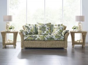 wicker cane sofa with green floral cushions